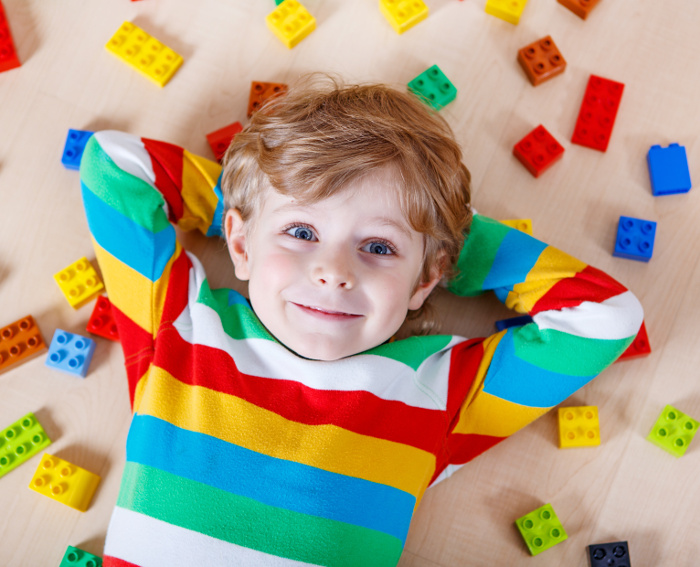 Coolest LEGO sets for kids - boy surrounded by LEGO pieces